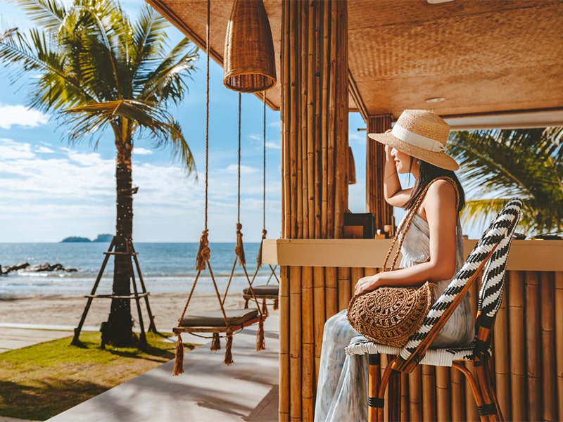 travel-summer-vacation-concept-happy-traveler-asian-woman-with-hat-dress-relax-swing-beach-cafe-koh-chang-thailand